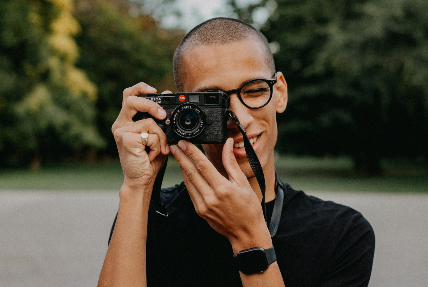 Djibril smiling whilst holding his Leica M6 Classic